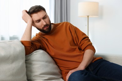 Photo of Loneliness concept. Sad man sitting on sofa at home