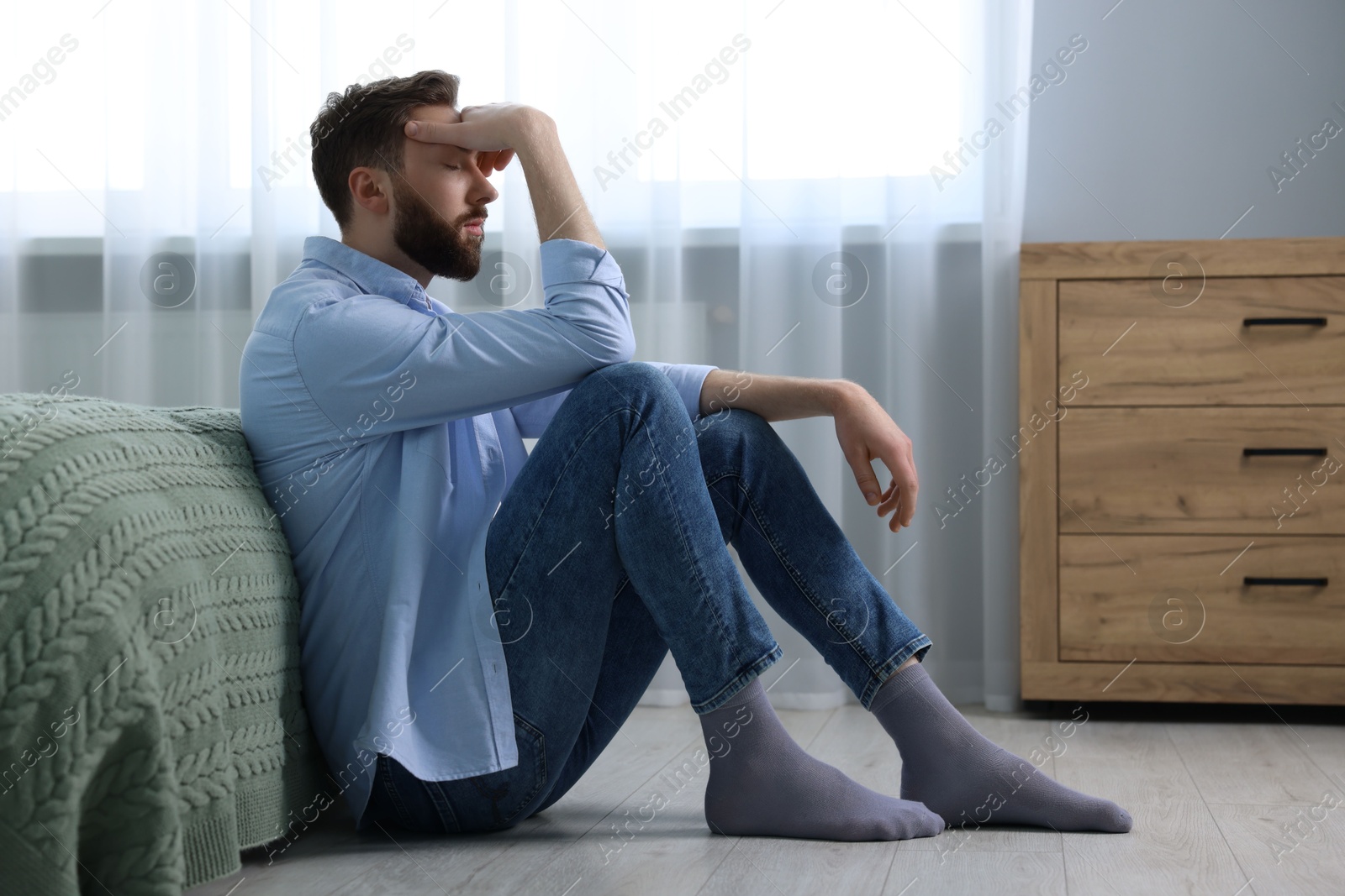 Photo of Loneliness concept. Sad man sitting on floor at home