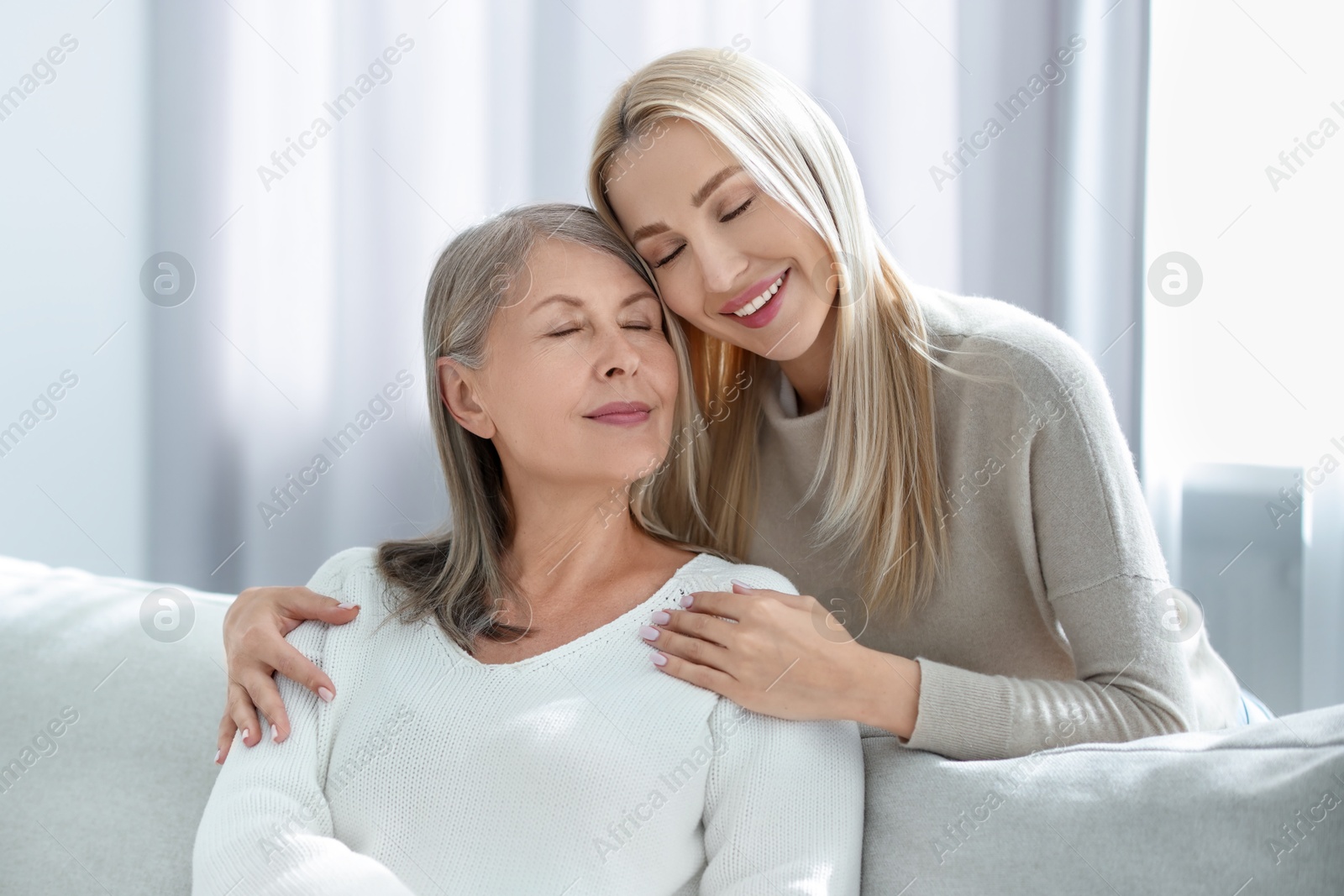 Photo of Family portrait of young woman and her mother at home