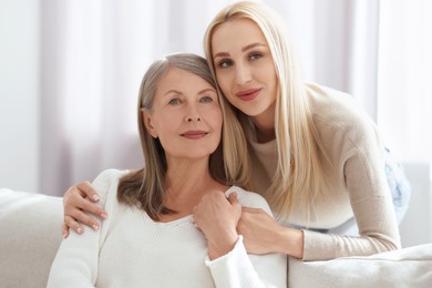 Family portrait of young woman and her mother at home