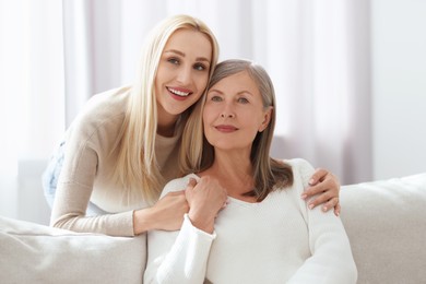 Family portrait of young woman and her mother at home