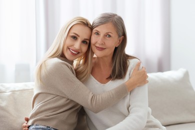 Family portrait of young woman and her mother at home