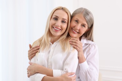 Family portrait of young woman and her mother on white background