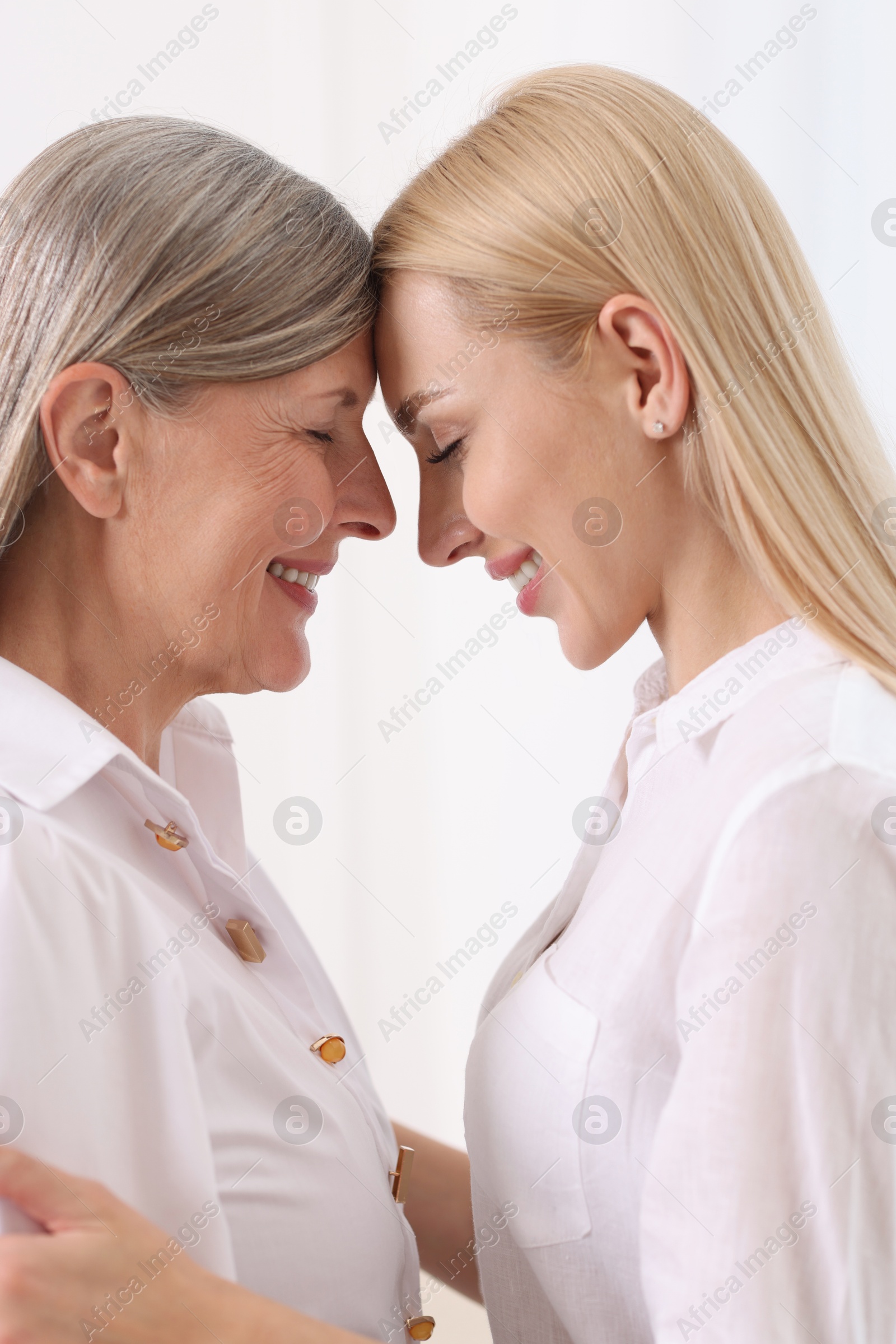 Photo of Family portrait of young woman and her mother on white background