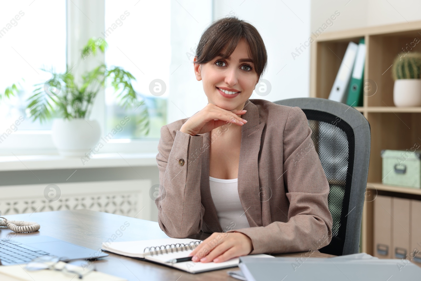 Photo of Portrait of smiling secretary at table in office