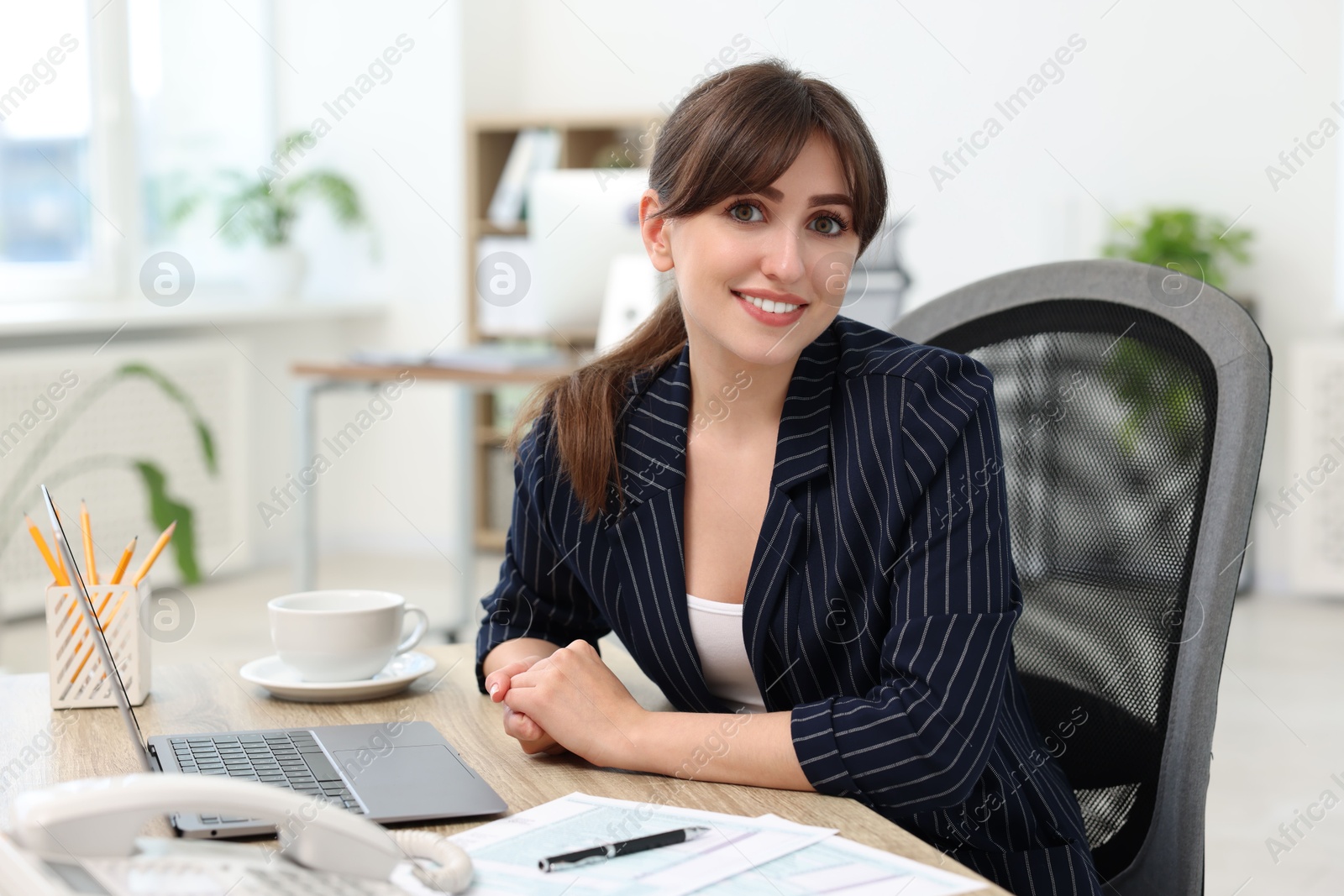 Photo of Portrait of smiling secretary at table in office