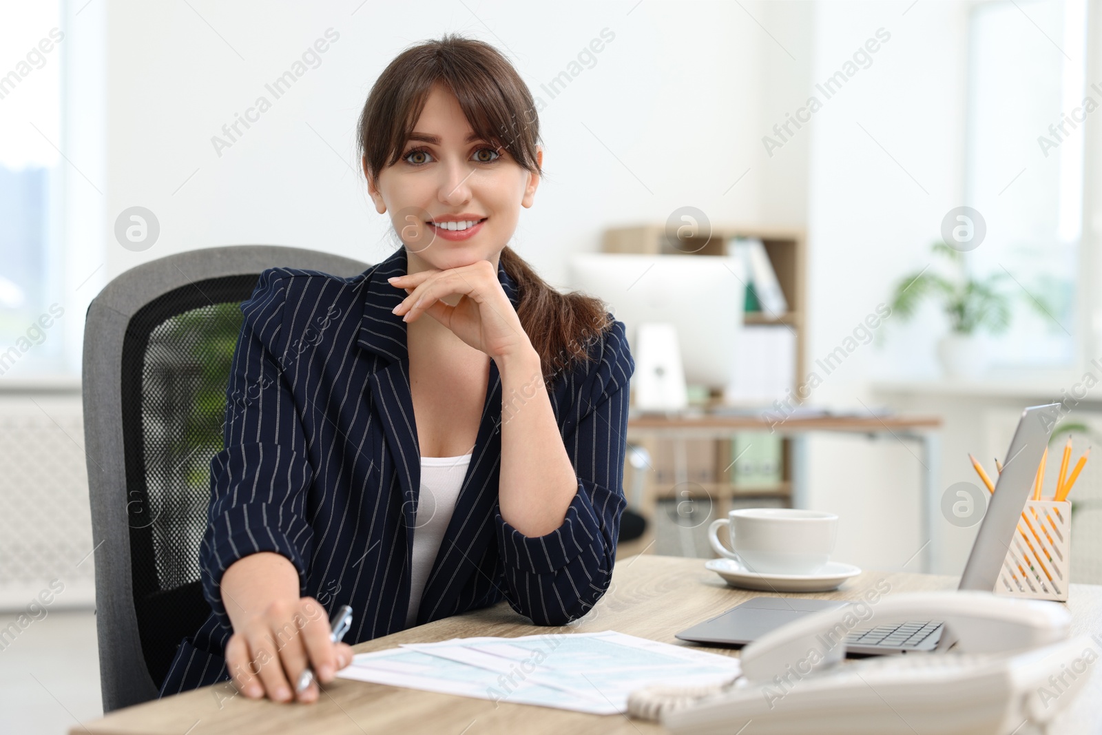 Photo of Portrait of smiling secretary at table in office