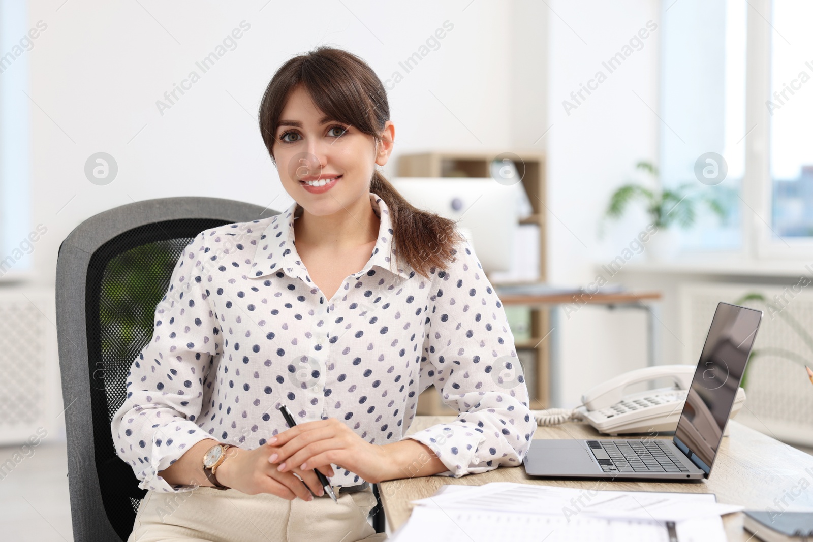 Photo of Portrait of smiling secretary at table in office