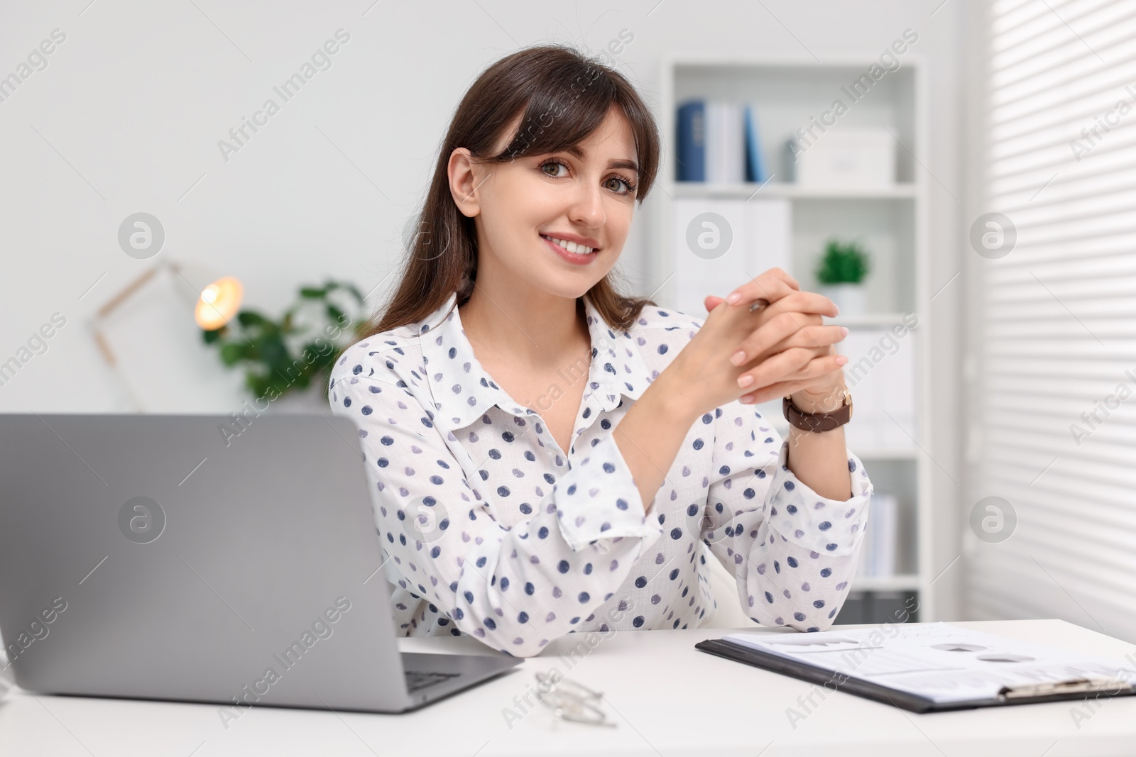 Photo of Portrait of smiling secretary at table in office