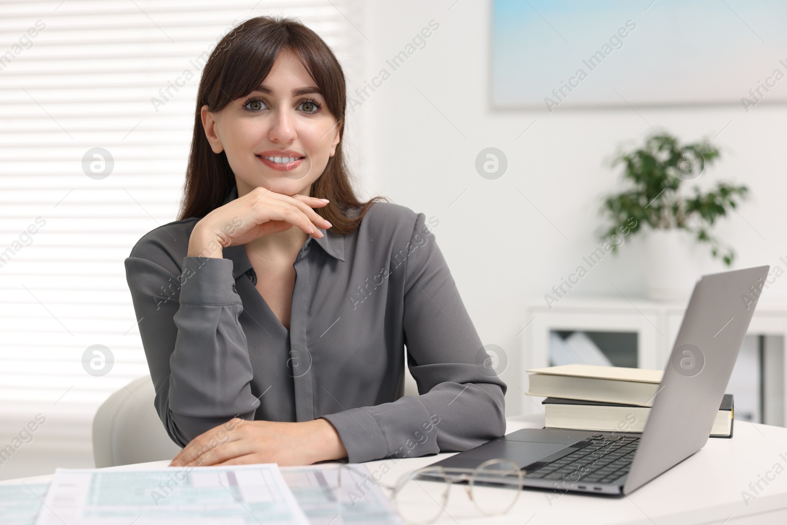 Photo of Portrait of smiling secretary at table in office