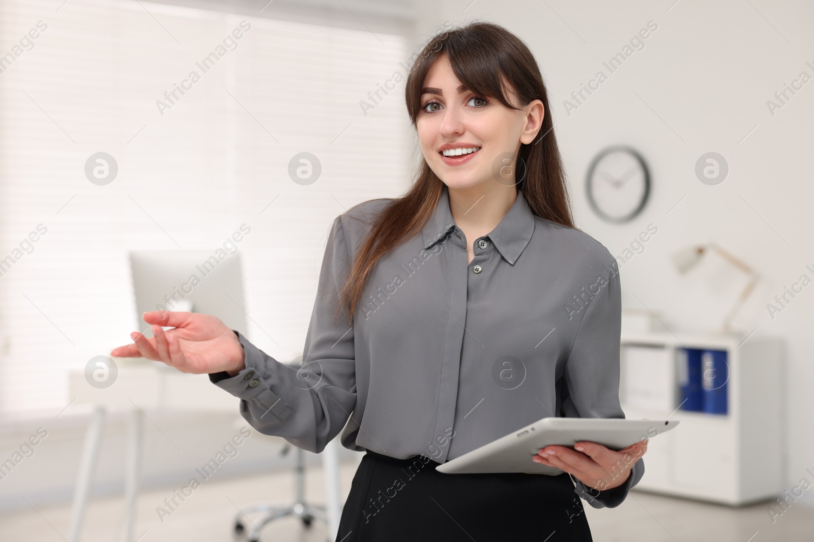 Photo of Portrait of smiling secretary with tablet in office