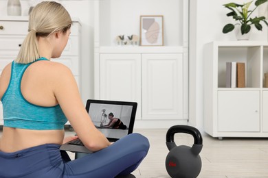 Online fitness trainer. Woman watching tutorial on laptop at home