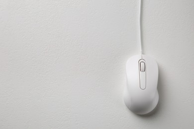 Photo of Wired mouse on light textured table, top view. Space for text
