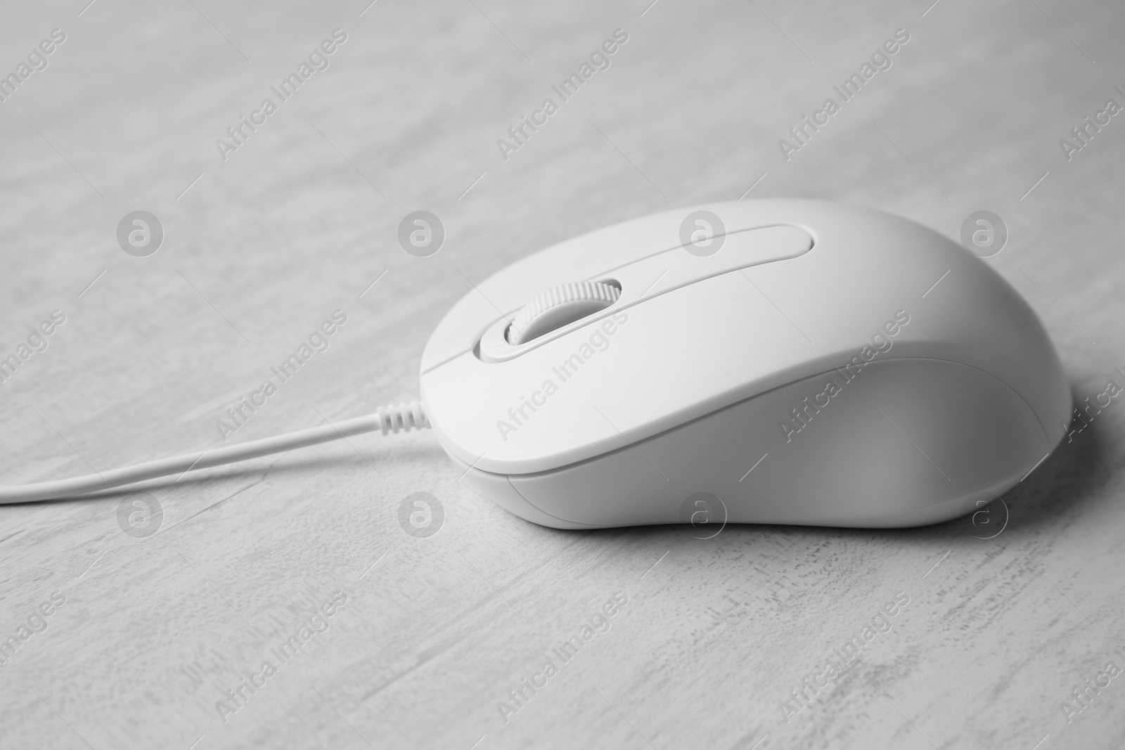 Photo of One wired mouse on grey wooden table, closeup