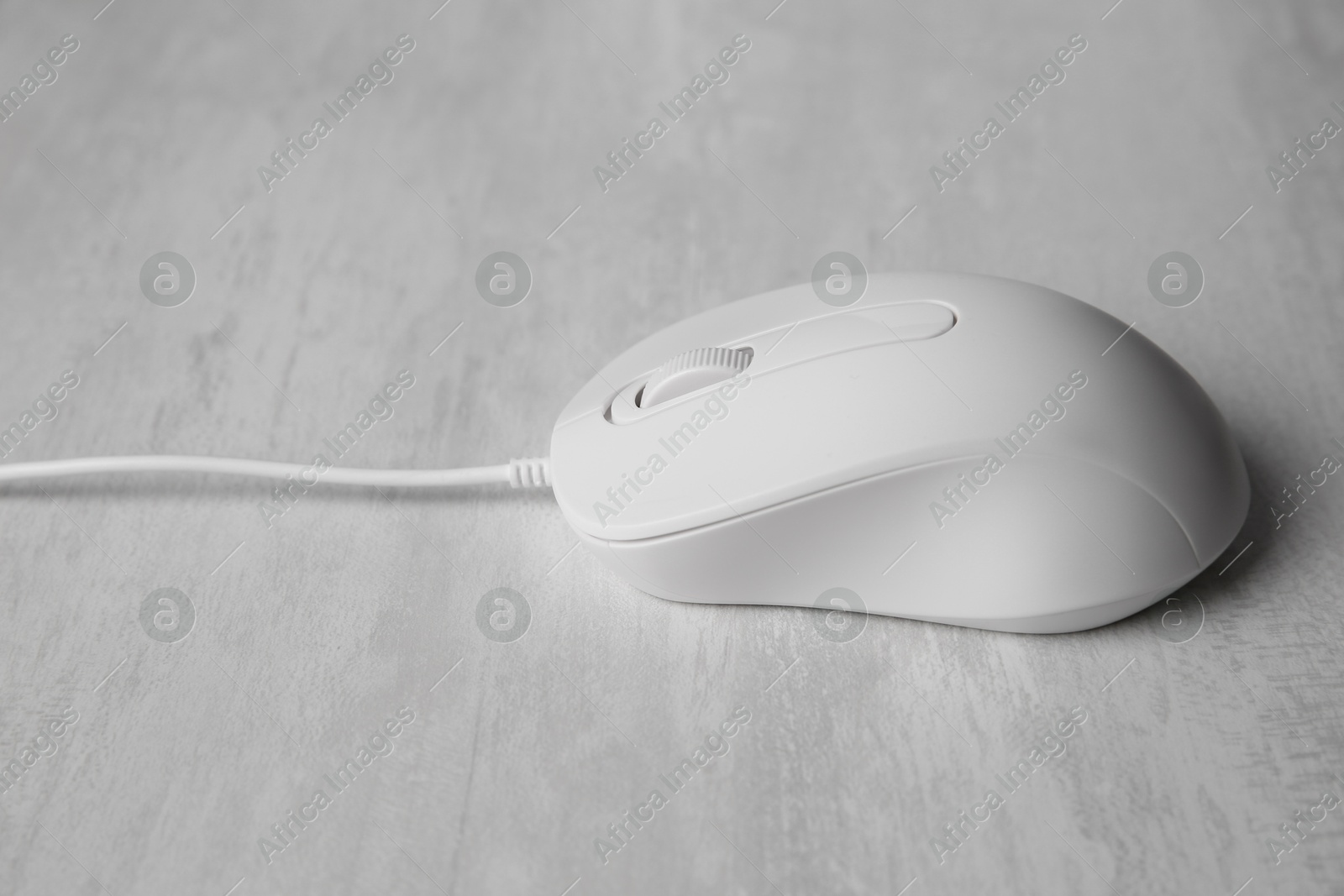 Photo of One wired mouse on grey wooden table, closeup
