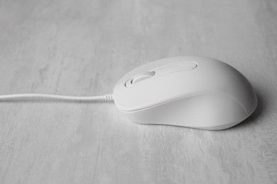 One wired mouse on grey wooden table, closeup