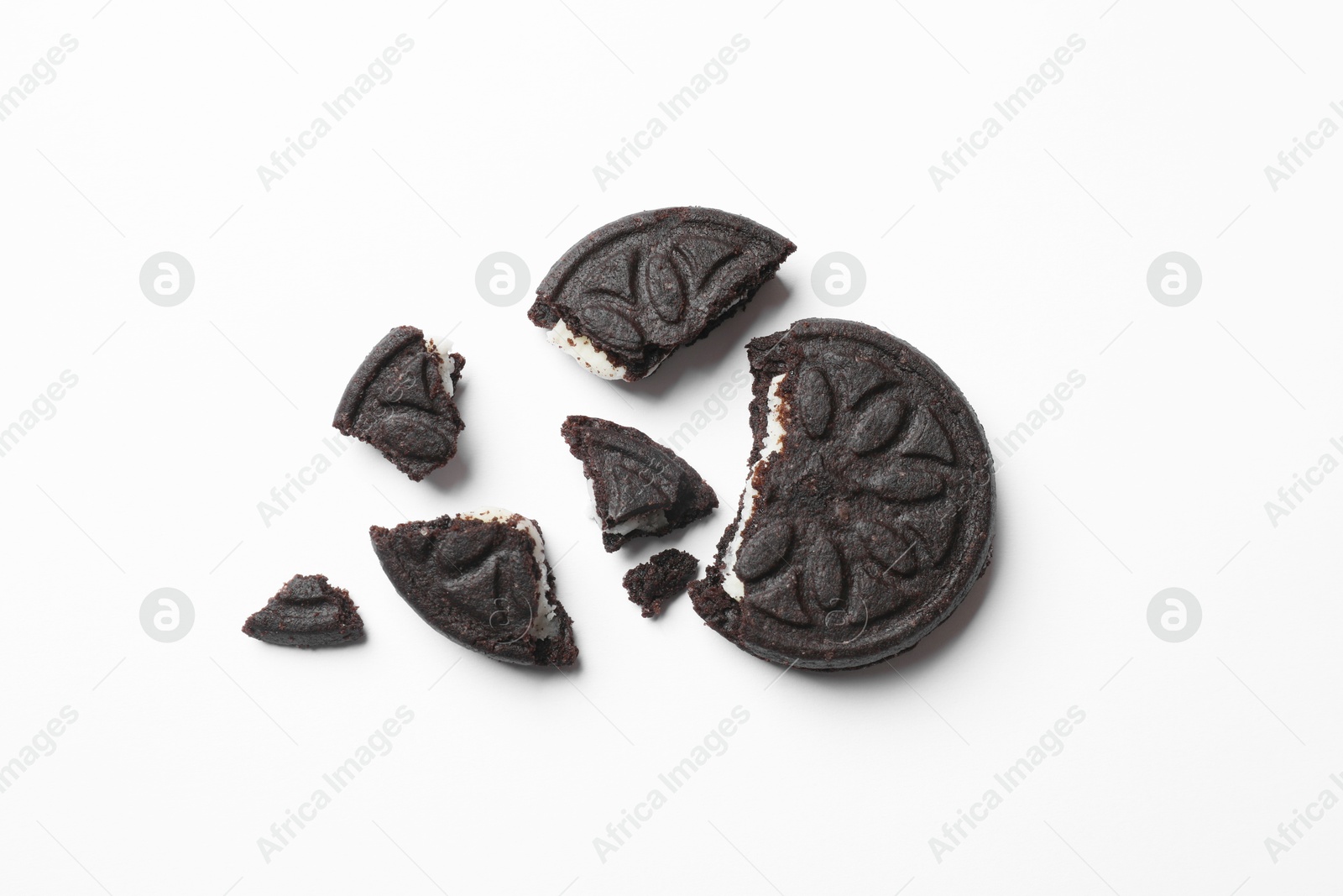 Photo of Pieces of tasty sweet sandwich cookies on white background, flat lay