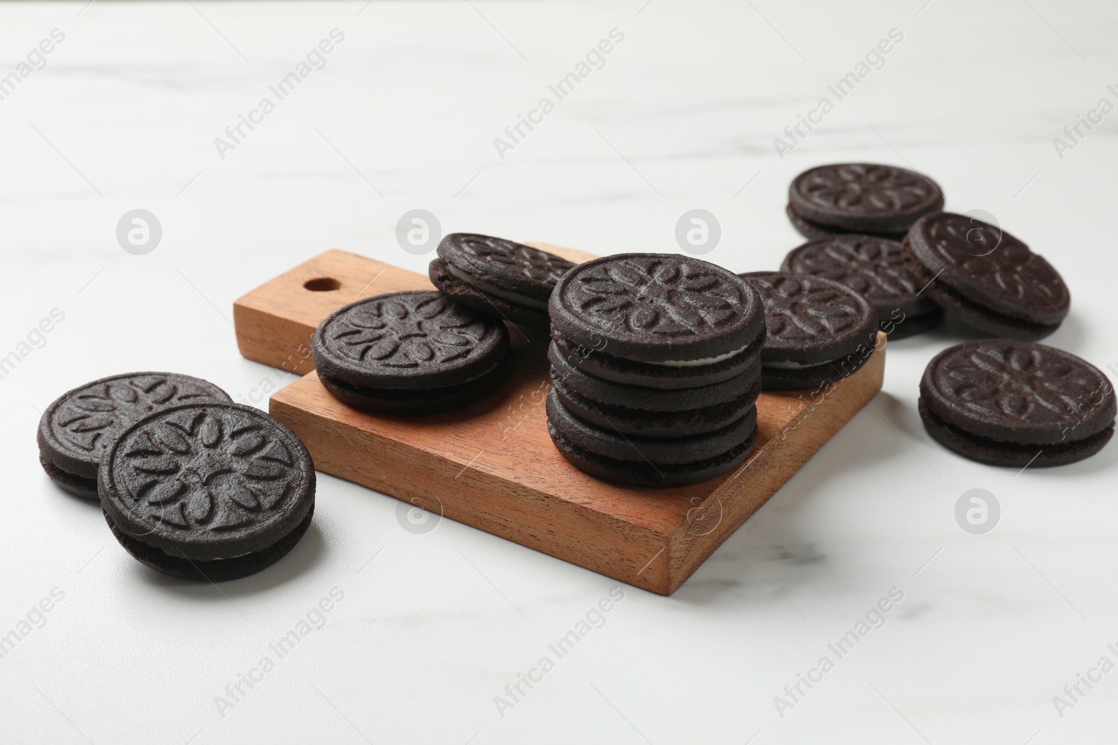 Photo of Tasty sandwich cookies on white table, closeup