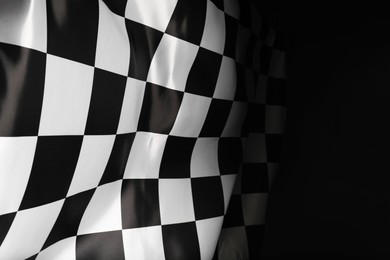 Checkered flag on black background, space for text
