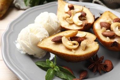 Delicious baked pears with nuts, ice cream, mint and honey on light table, closeup