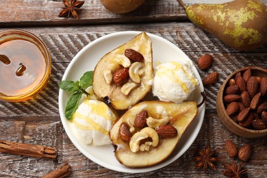 Photo of Delicious baked pears with nuts, ice cream, anise stars and honey on wooden rustic table, flat lay