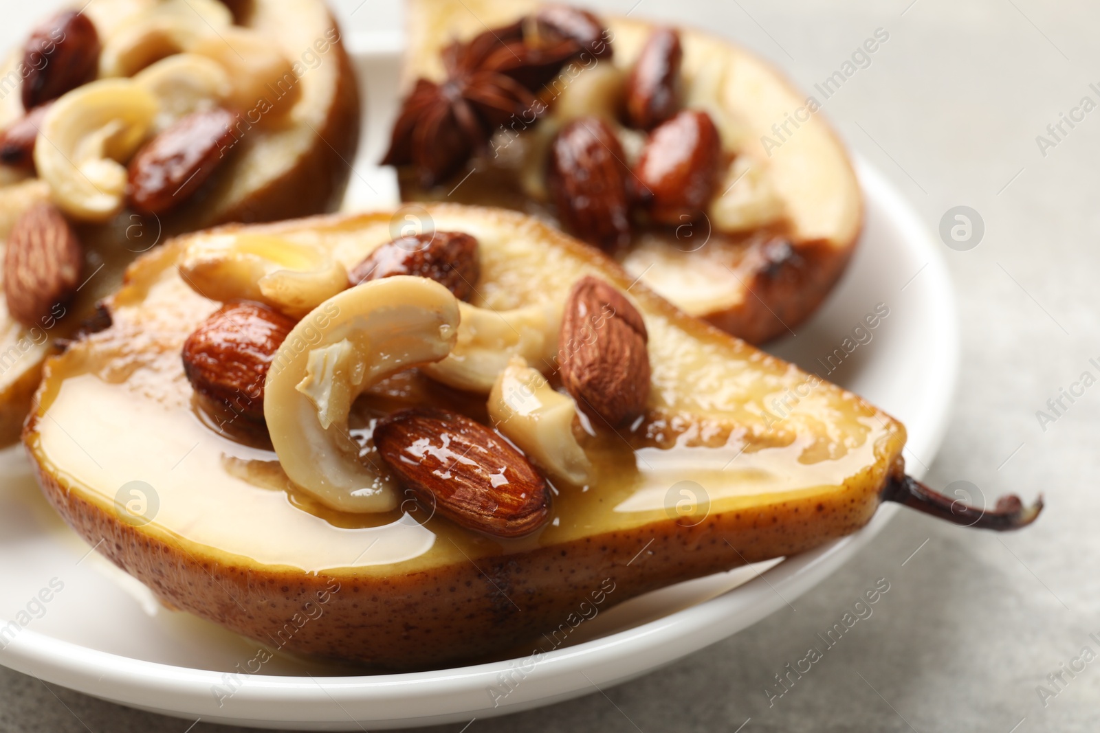 Photo of Delicious baked pears with nuts and honey on light table, closeup