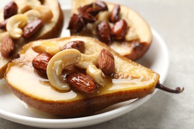 Delicious baked pears with nuts and honey on light table, closeup