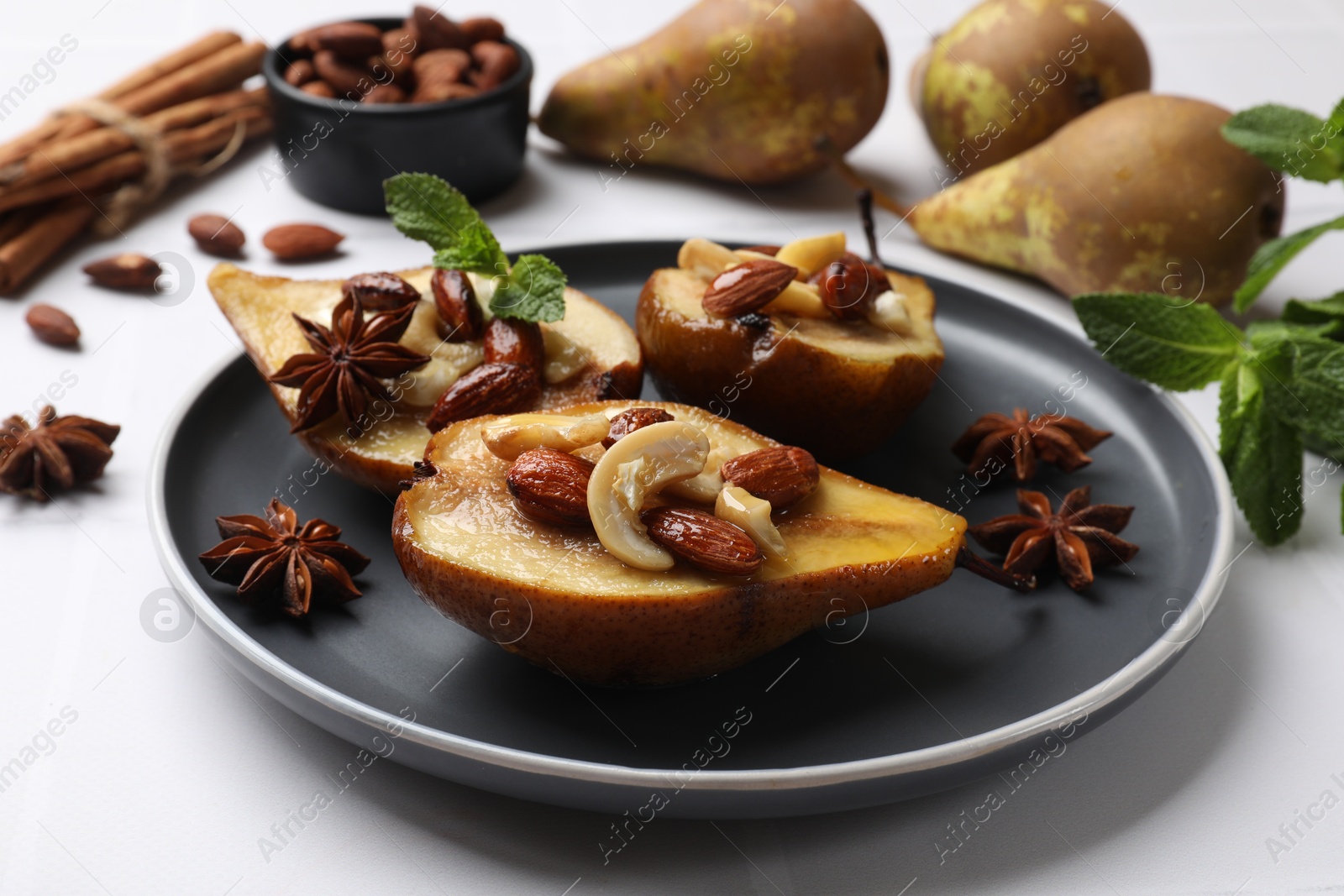 Photo of Delicious baked pears with nuts and anise stars on white table, closeup