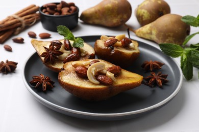 Photo of Delicious baked pears with nuts and anise stars on white table, closeup