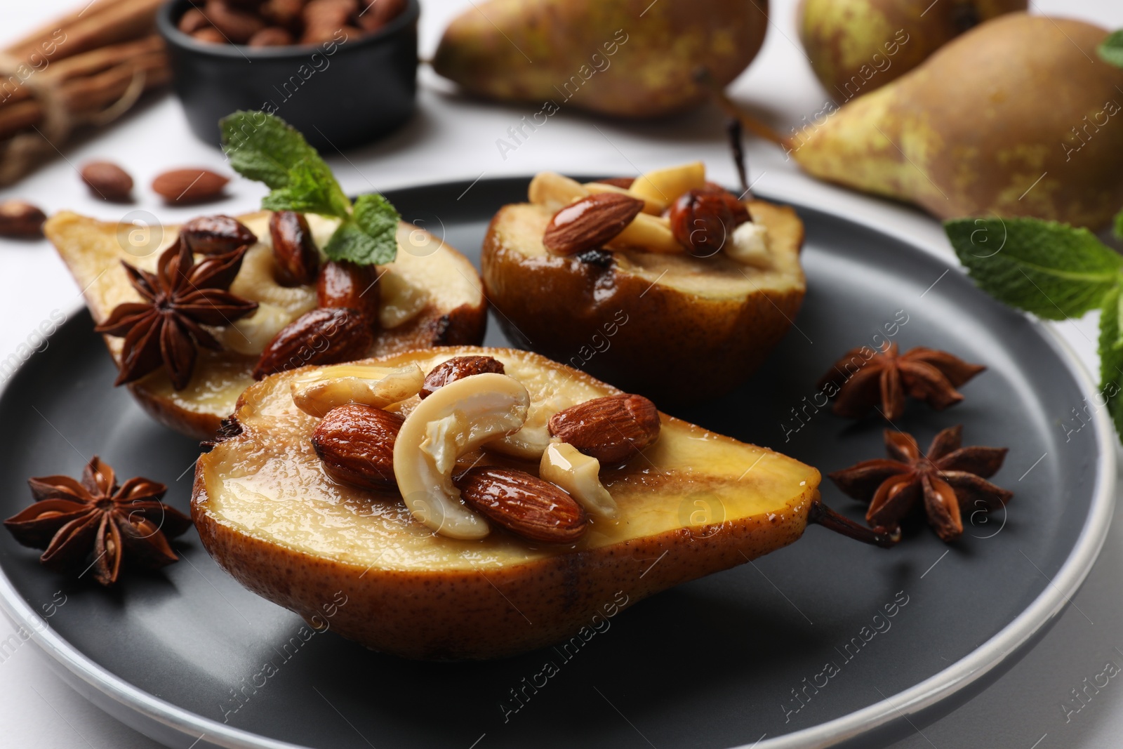 Photo of Delicious baked pears with nuts and anise stars on white table, closeup