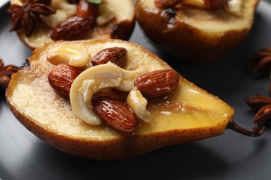 Delicious baked pears with nuts on plate, closeup