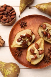 Photo of Delicious baked pears with nuts and anise stars on light wooden table, flat lay