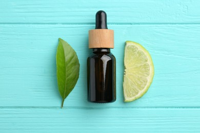 Bottle of essential oil, lime and green leaf on turquoise wooden table, flat lay