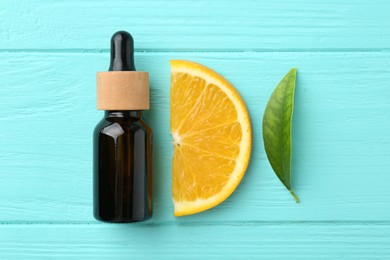 Bottle of essential oil, orange and green leaf on turquoise wooden table, flat lay