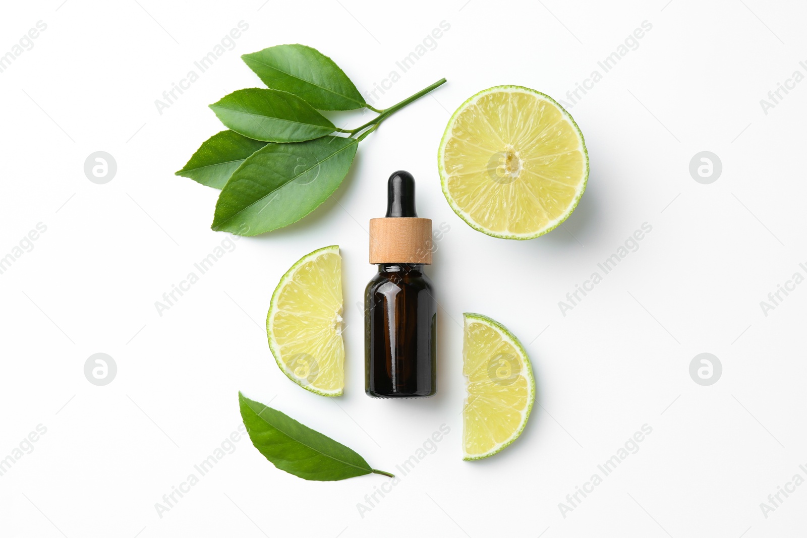 Photo of Bottle of essential oil, lime and green leaves on white background, flat lay