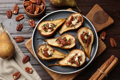 Delicious baked pears with nuts, blue cheese and honey on wooden table, flat lay