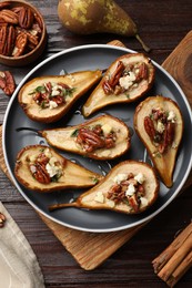 Photo of Delicious baked pears with nuts, blue cheese and honey on wooden table, flat lay