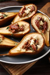 Delicious baked pears with nuts, blue cheese and honey on table, closeup