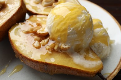 Photo of Delicious baked pears with nuts, ice cream and honey on plate, closeup