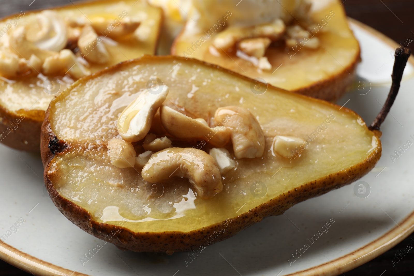 Photo of Delicious baked pears with nuts and honey on plate, closeup