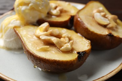 Delicious baked pears with nuts and honey on plate, closeup