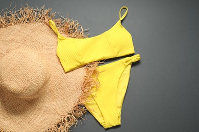 Photo of Yellow swimsuit and hat on grey background, flat lay. Space for text