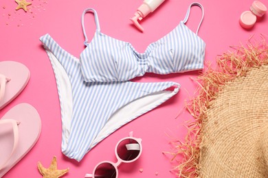 Flat lay composition with striped swimsuit on pink background