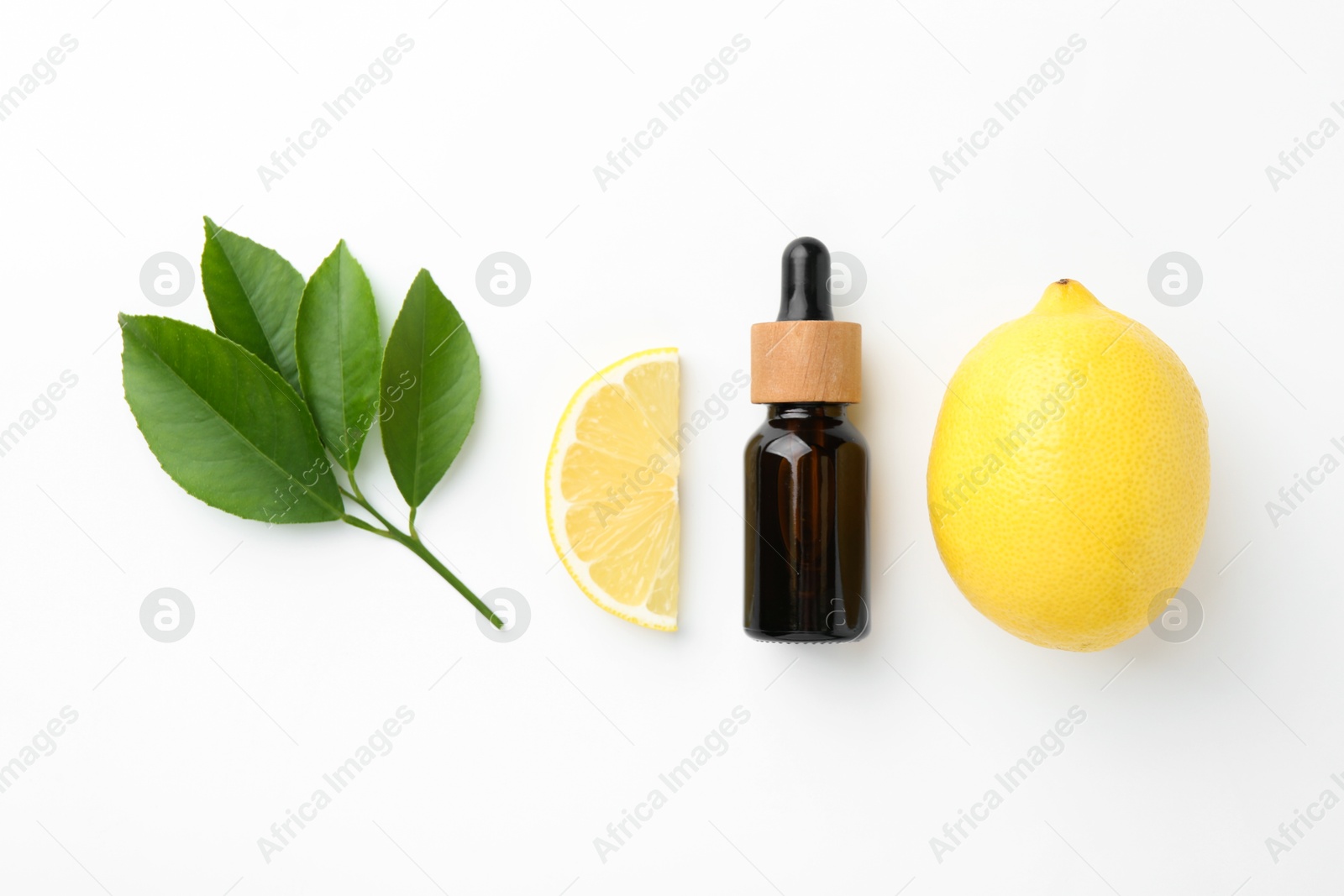 Photo of Bottle of essential oil, lemon and green leaves on white background, flat lay