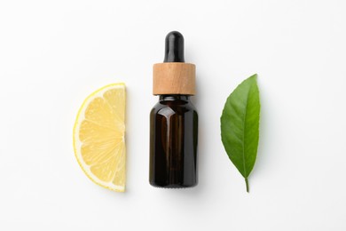 Bottle of essential oil, lemon and green leaf on white background, flat lay