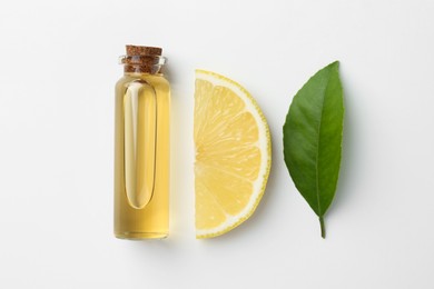 Bottle of essential oil, lemon and green leaf on white background, flat lay