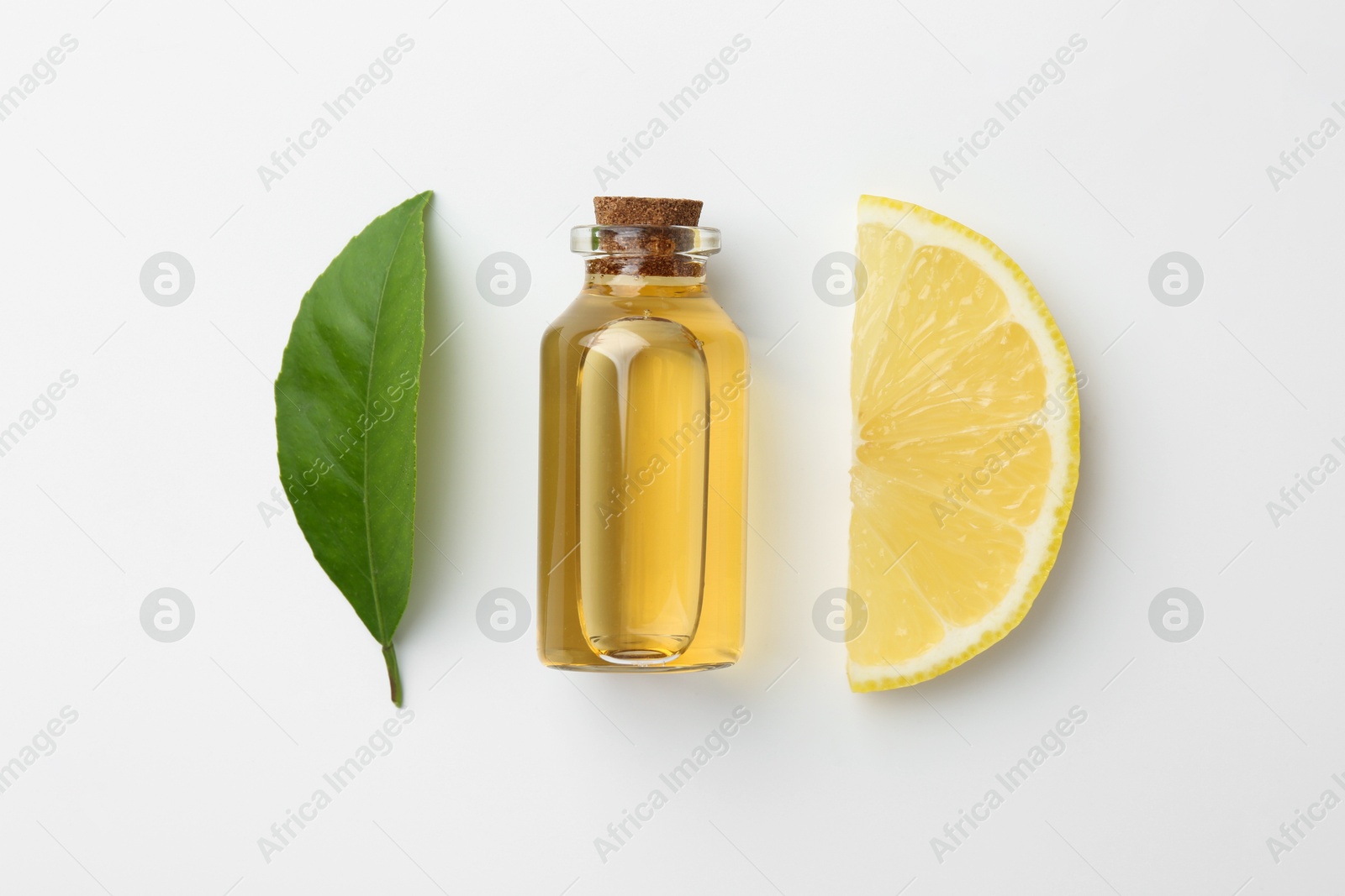 Photo of Bottle of essential oil, lemon and green leaf on white background, flat lay