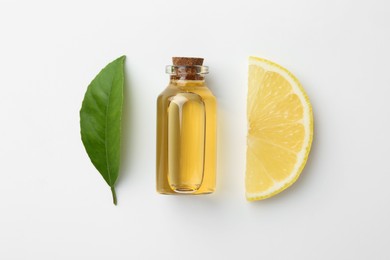 Bottle of essential oil, lemon and green leaf on white background, flat lay