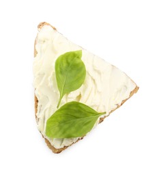 Photo of Piece of bread with cream cheese and basil leaves isolated on white, top view