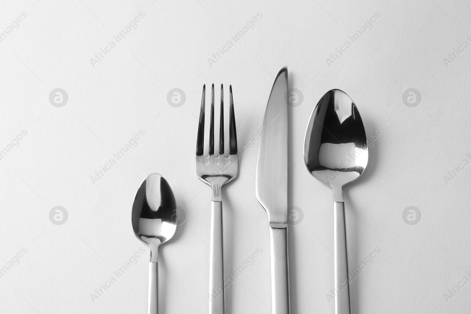 Photo of Stylish silver cutlery on white background, flat lay